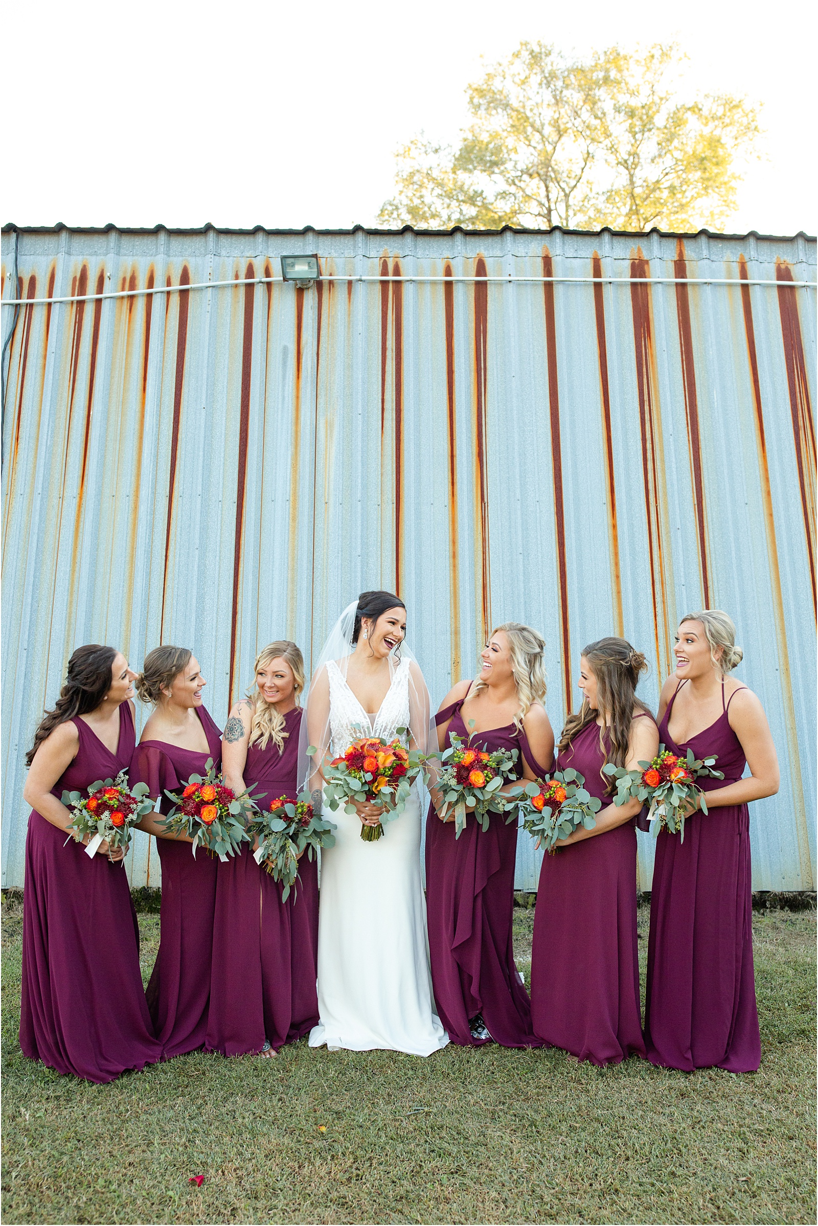 woman in wedding gown holds flowers while standing with her girlfriends
