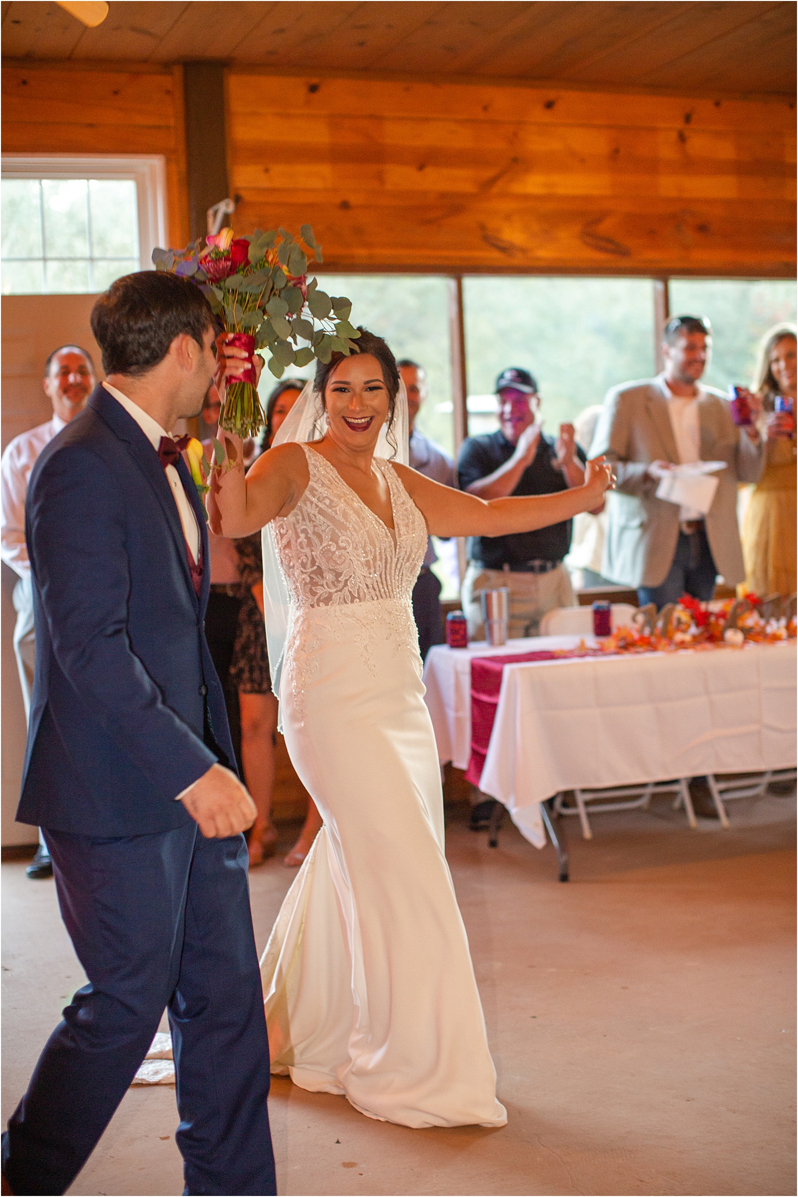 bride dancing as her and new husband walk into wedding reception