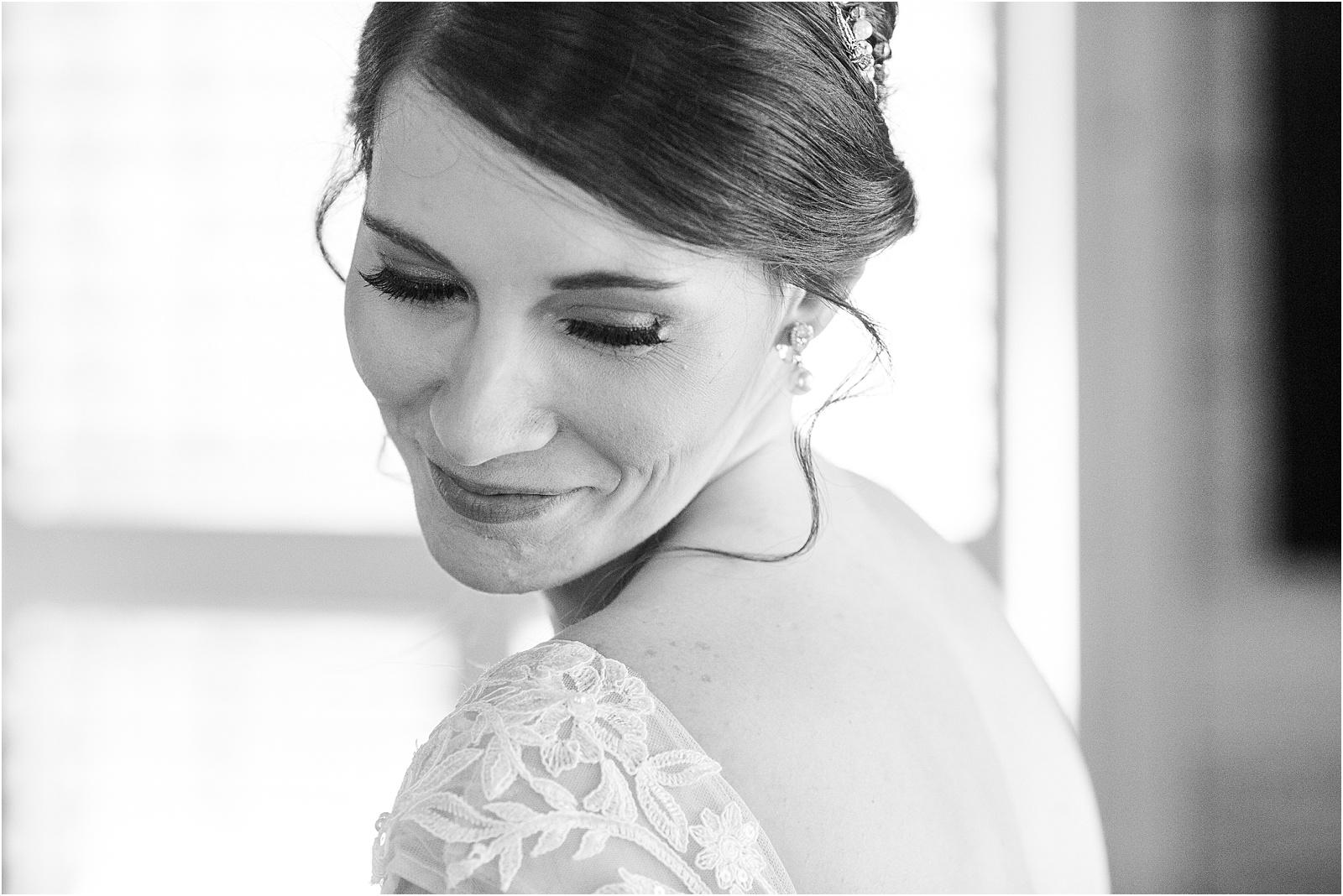 bride looks over her shoulder while getting dress for wedding