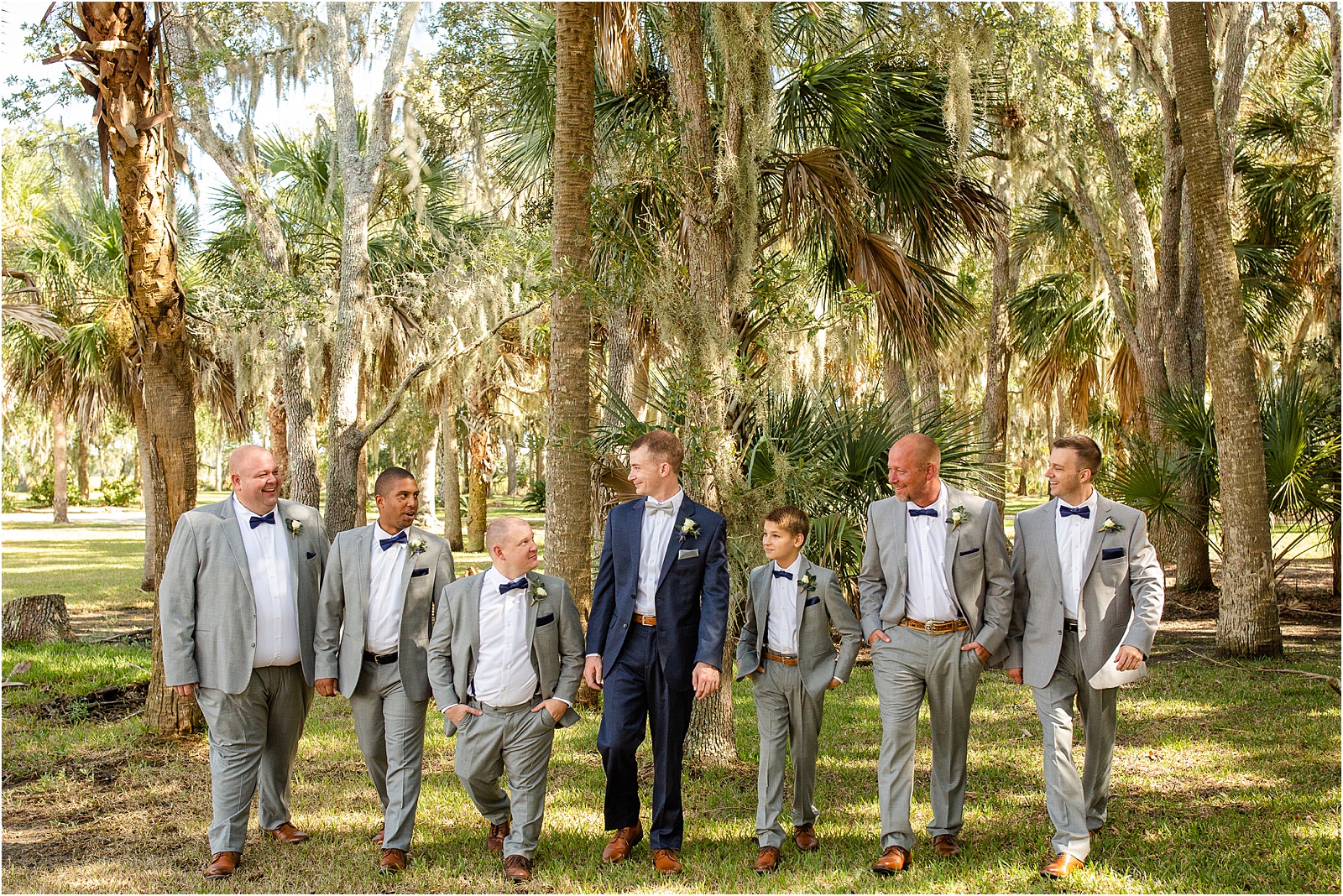 Groom looking at his groomsmen and laughing while they walk together