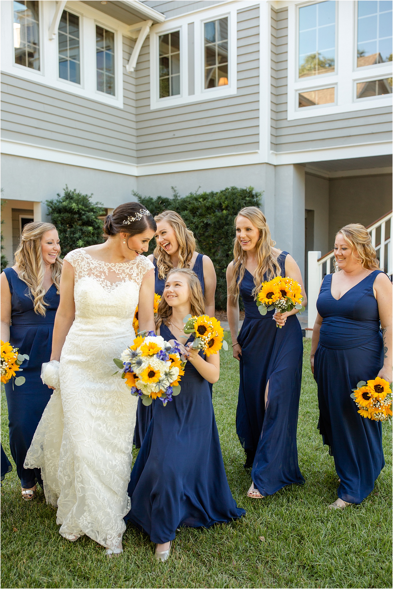 bride and her bridesmaids in blue dresses laughing as they walk