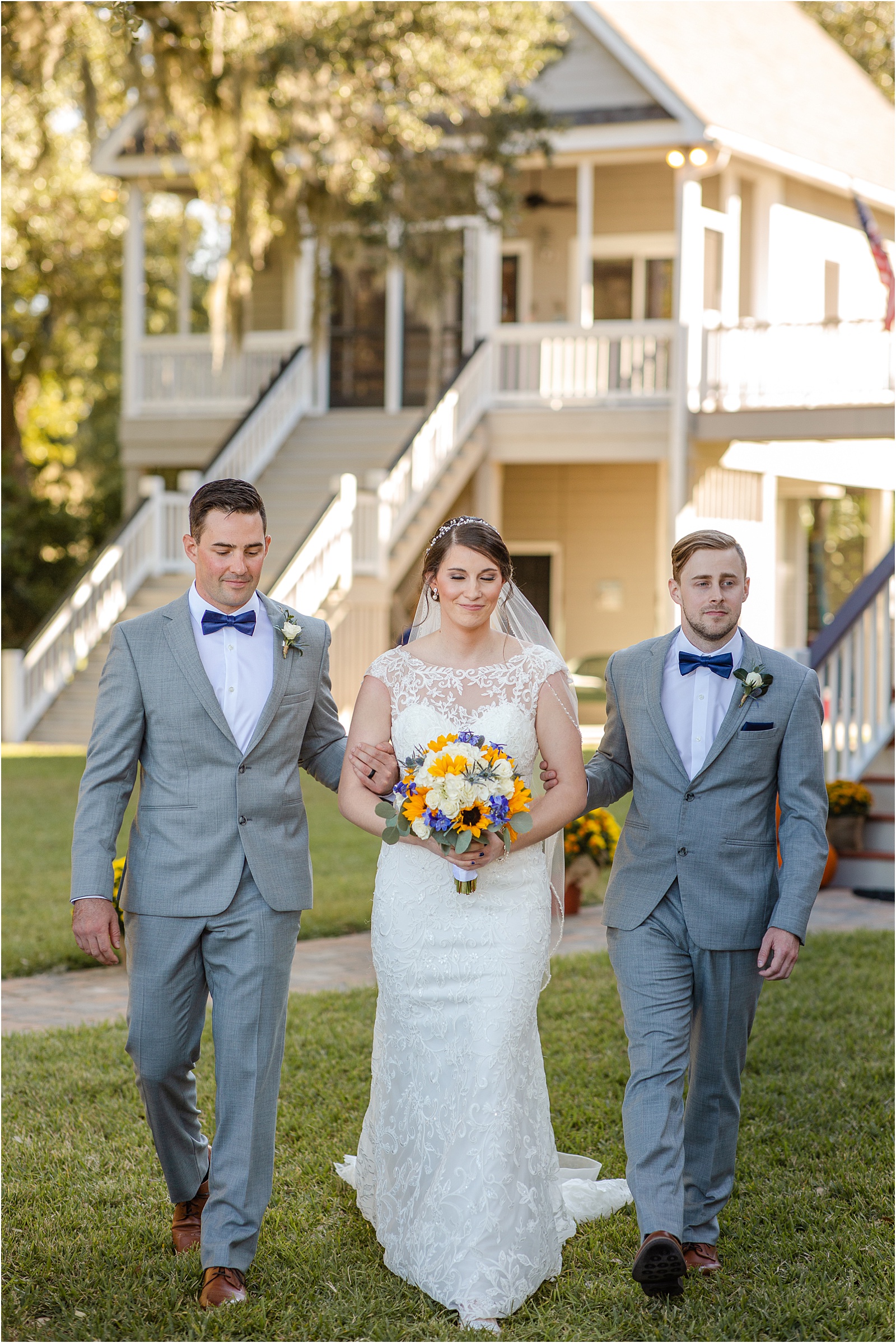 bride in wedding dress walking down the aisle with brothers on her arms