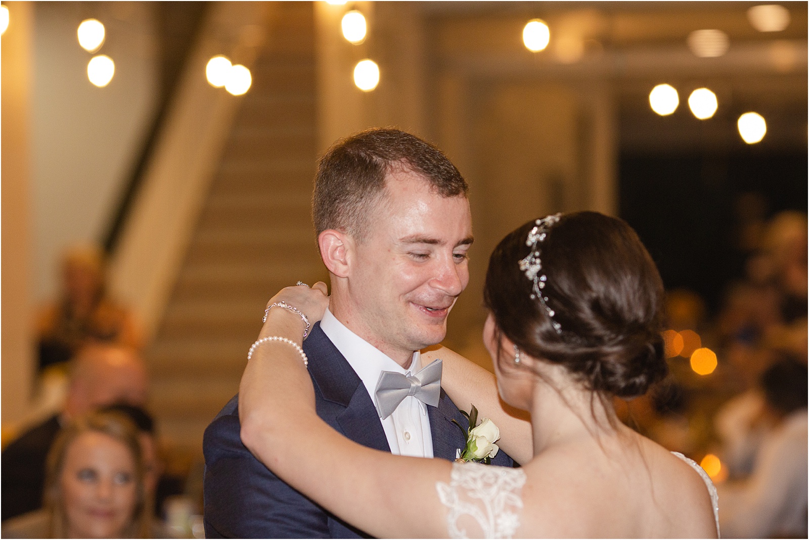 Groom talks to bride during their first dance as a married couple
