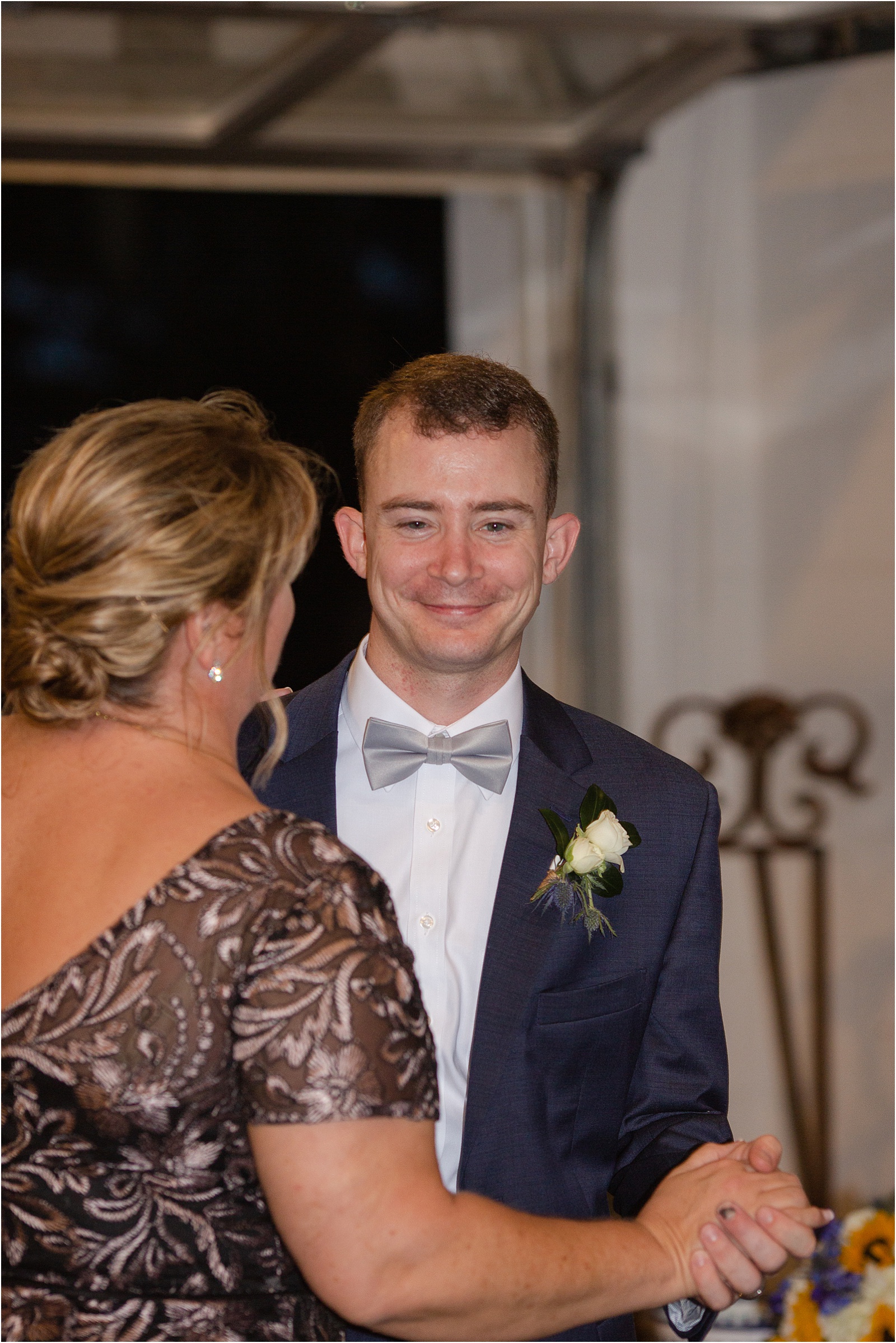 Groom smiles as he dances with his mother