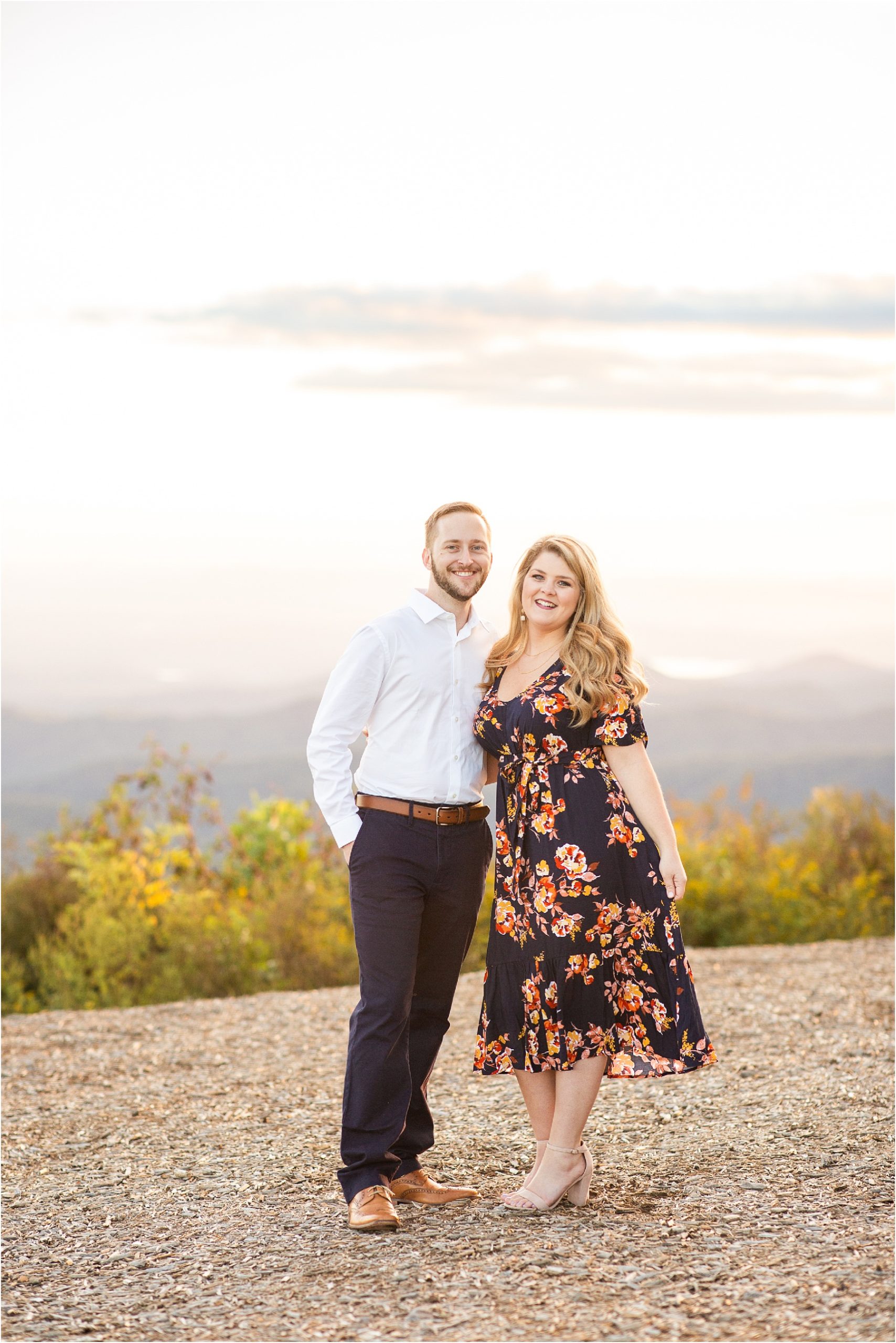 Girl in floral dress and guy in dress clothes on a South Carolina mountain for engagement pictures