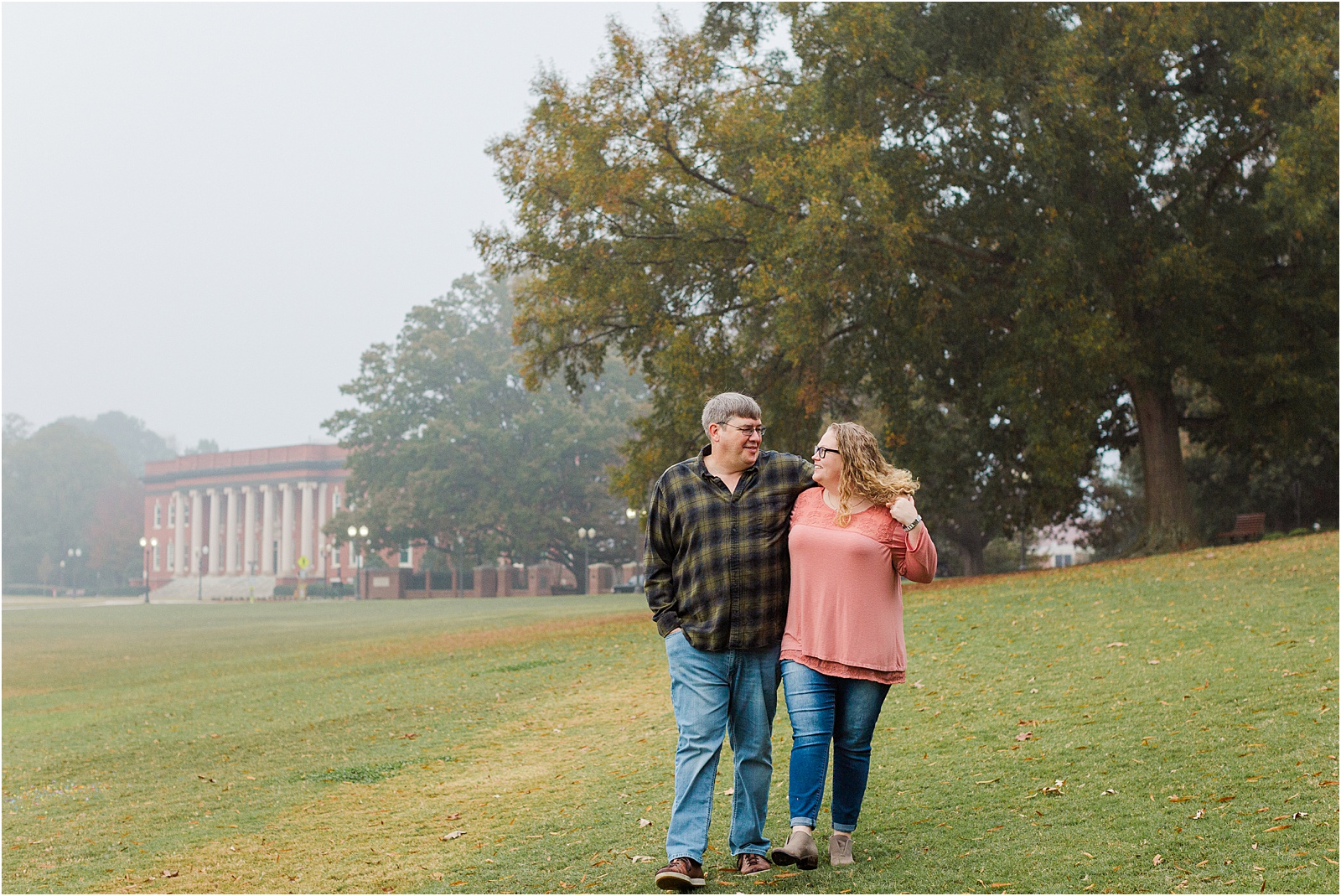 couple with arms around each other walking across Clemson campus