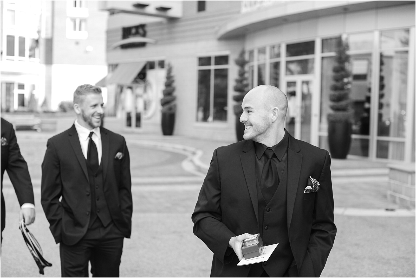 groom walking in Downtown Greenville looking back at his groomsmen