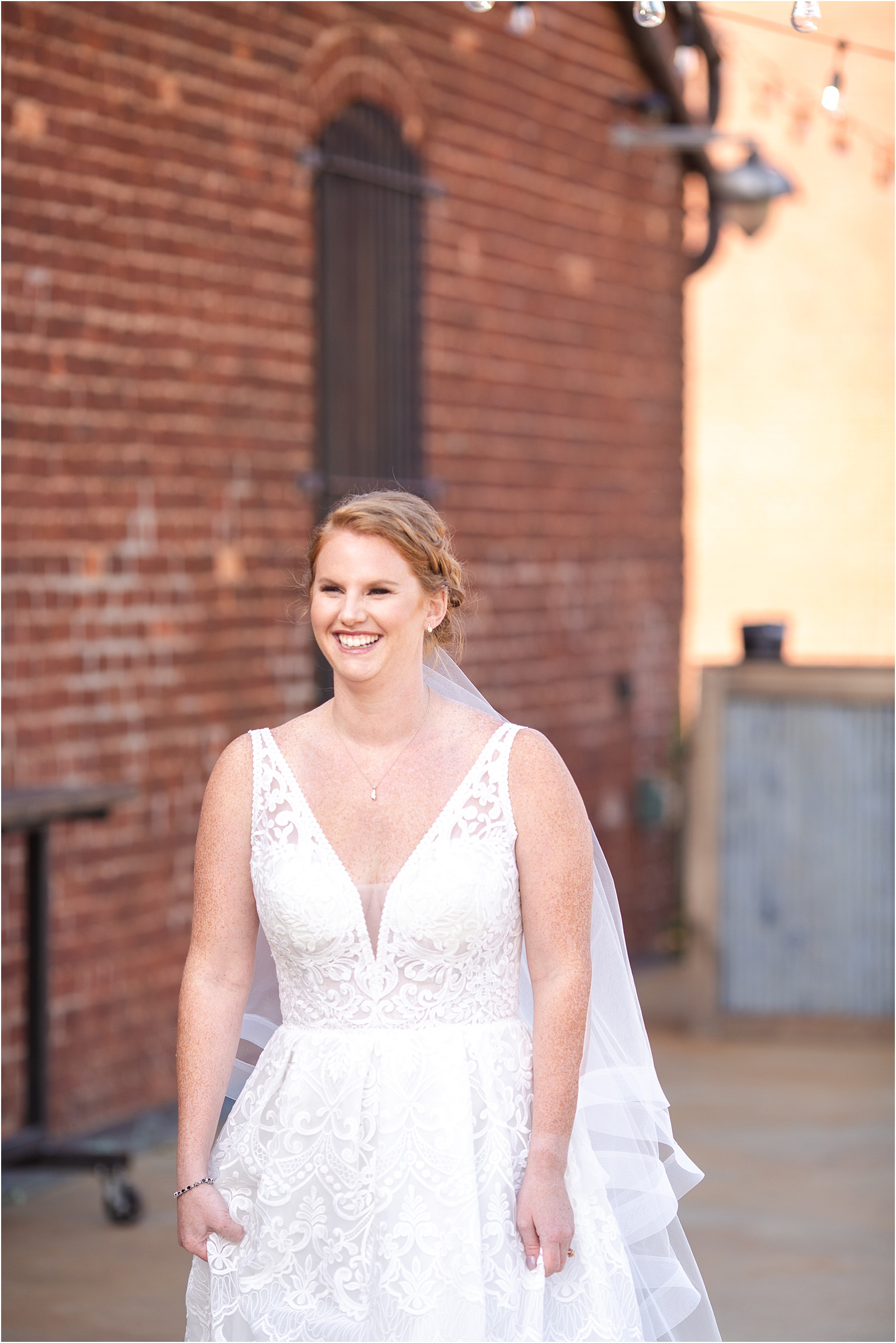 bride walking towards groom with brick wall in the background