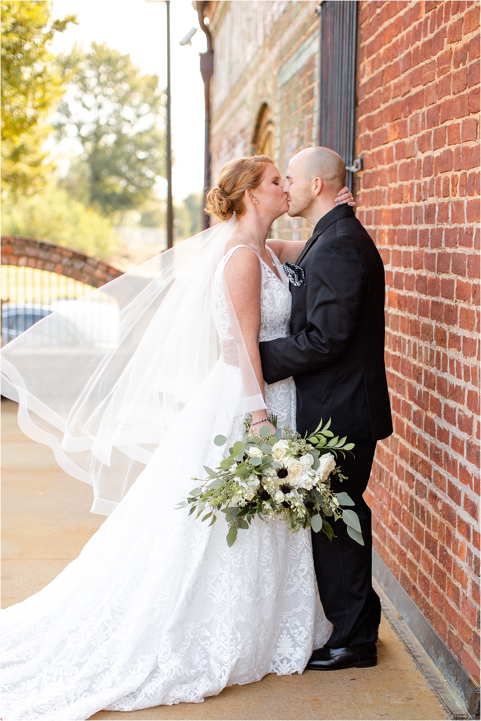Married couple kissing next to old cigar warehouse