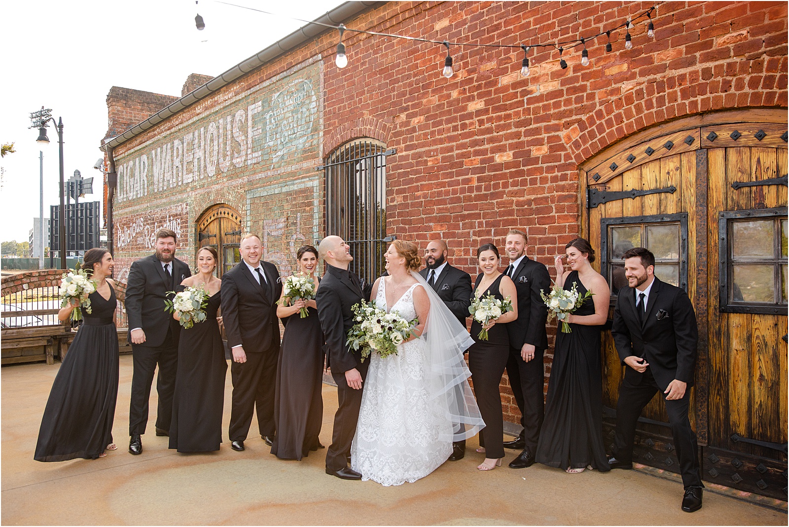 bridal party lined up outside old cigar warehouse brick wall