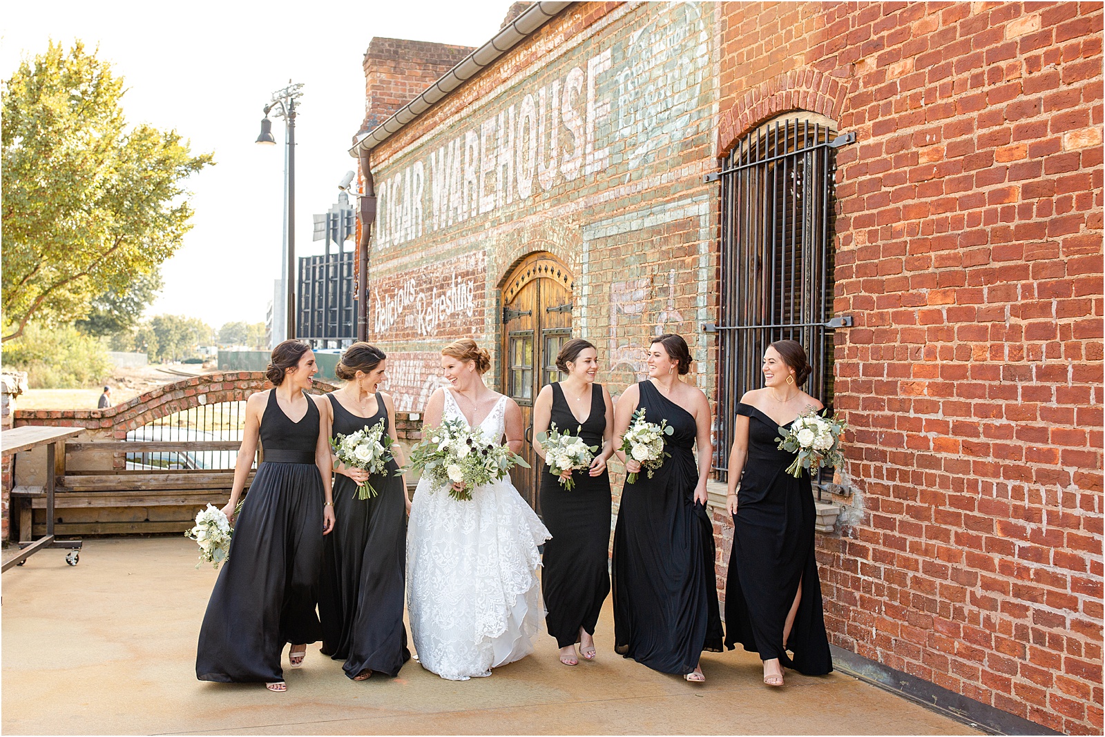 Bride walking with her bridesmaids outside Old Cigar Warehouse