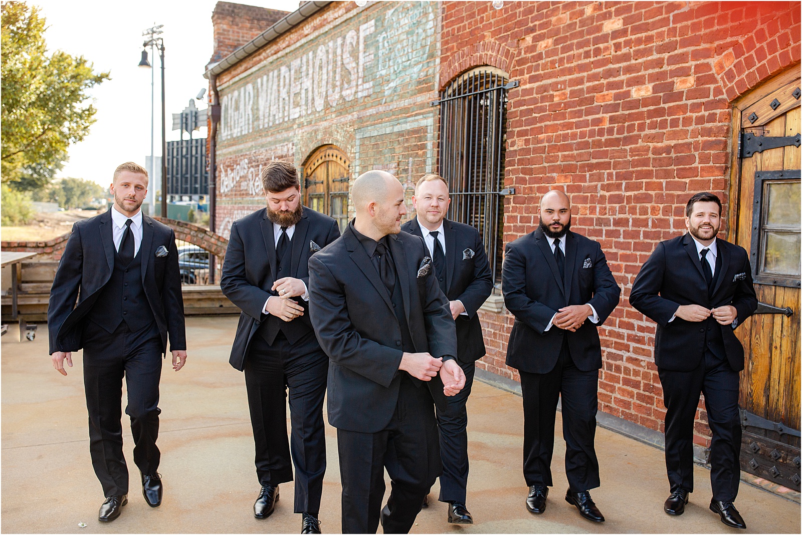 groom and groomsmen walking outside Old Cigar Warehouse