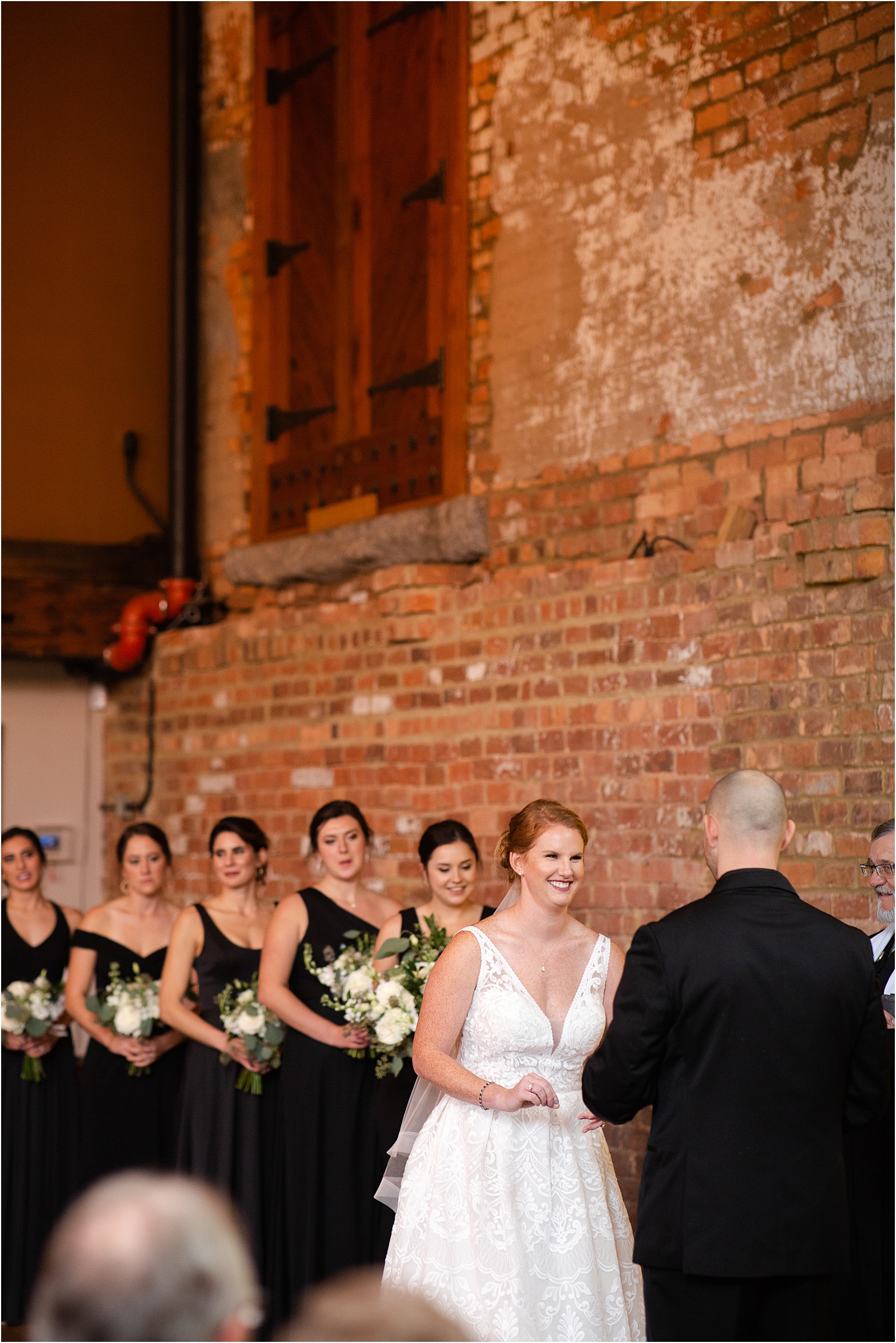 bride and bridal party during wedding ceremony at old cigar warehouse