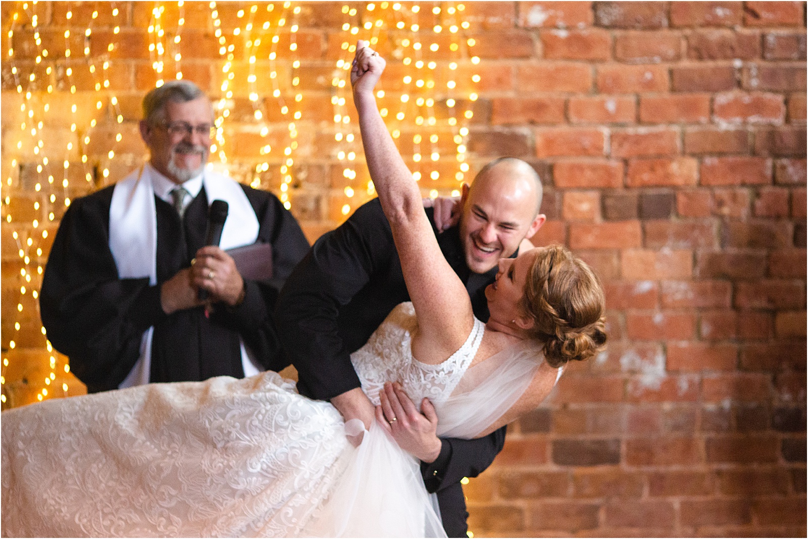groom dips his bride as they share their first kiss
