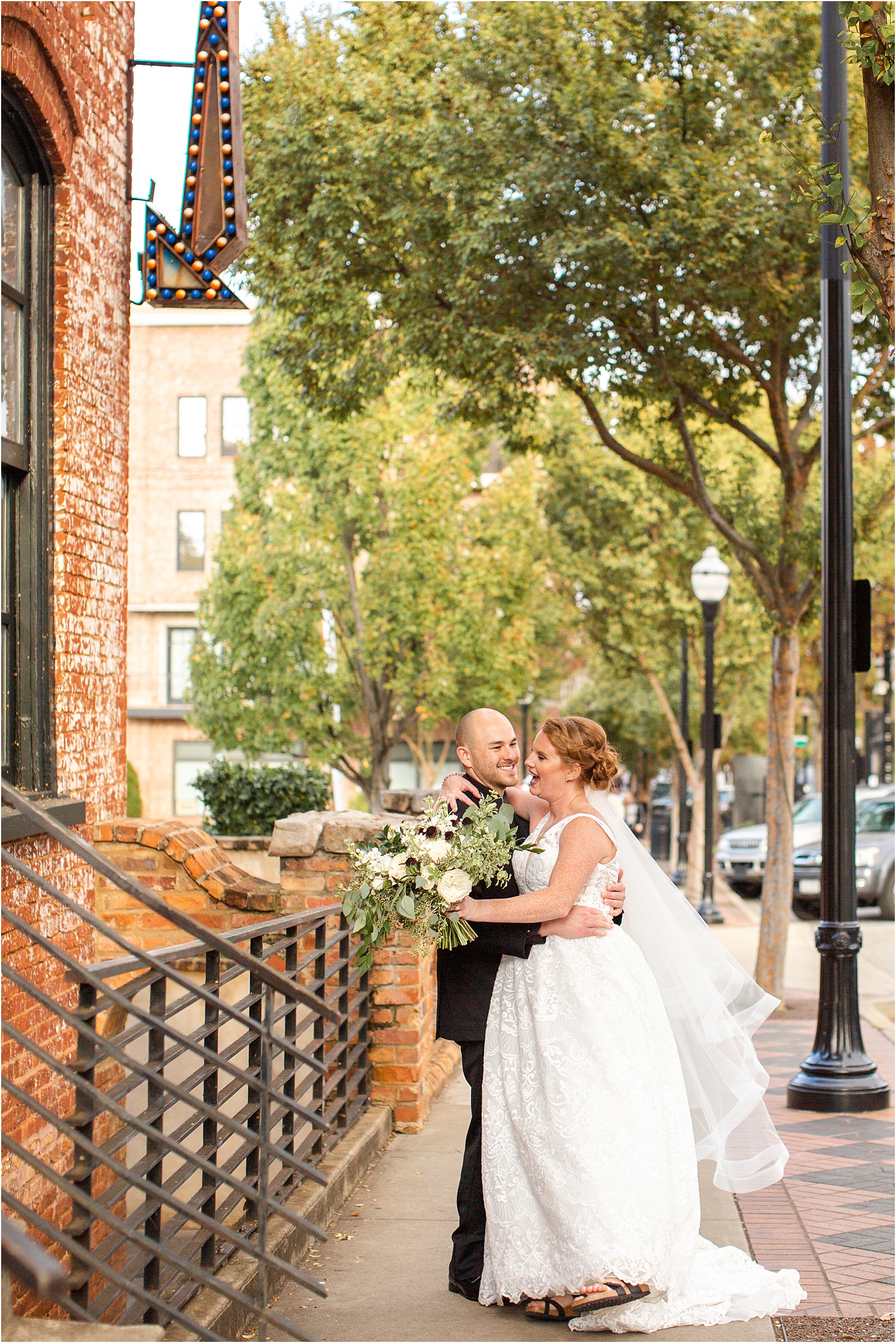 Bride looks at her new husband and laughs in Downtown Greenville street