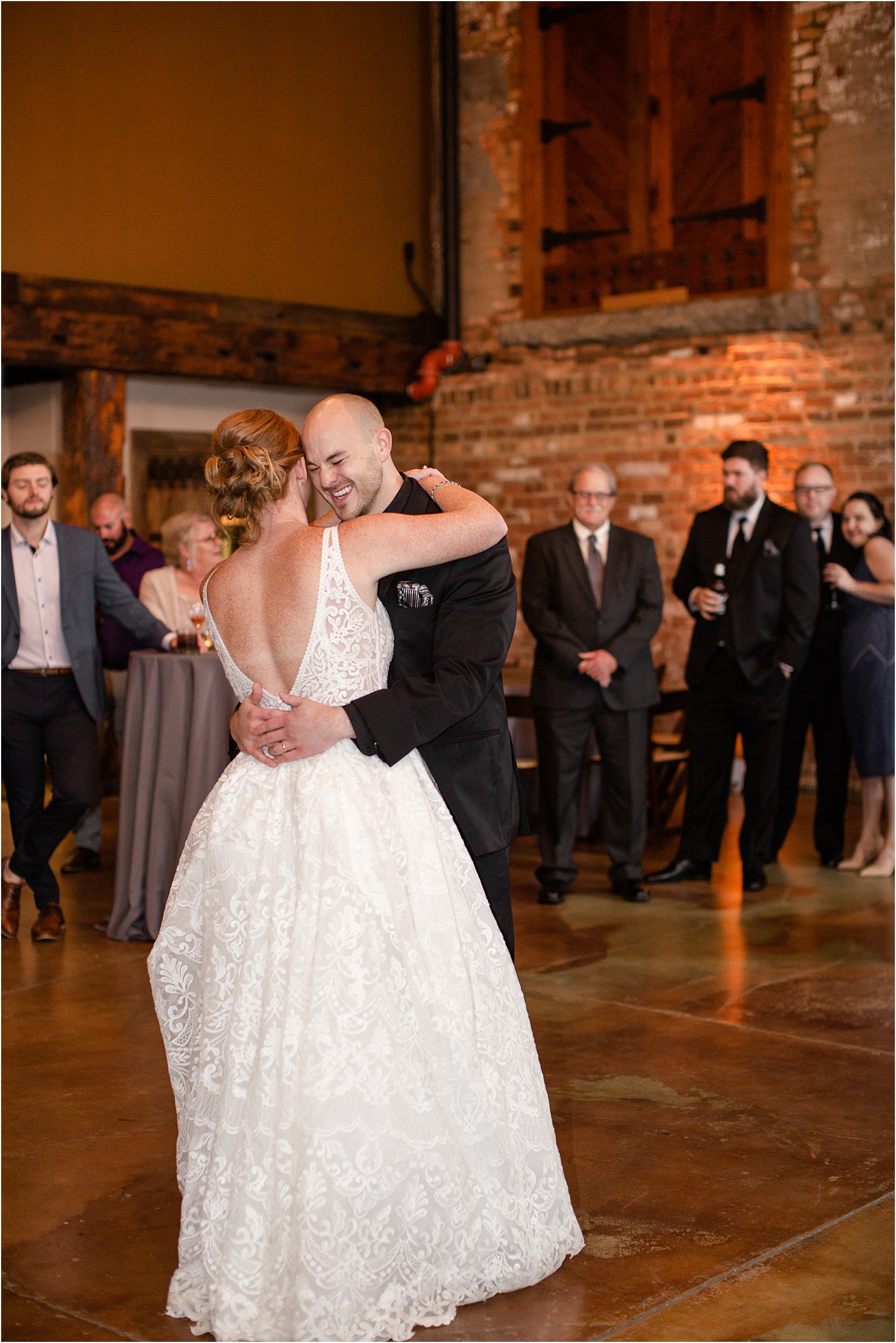 Groom smiles as he dances with his new bride