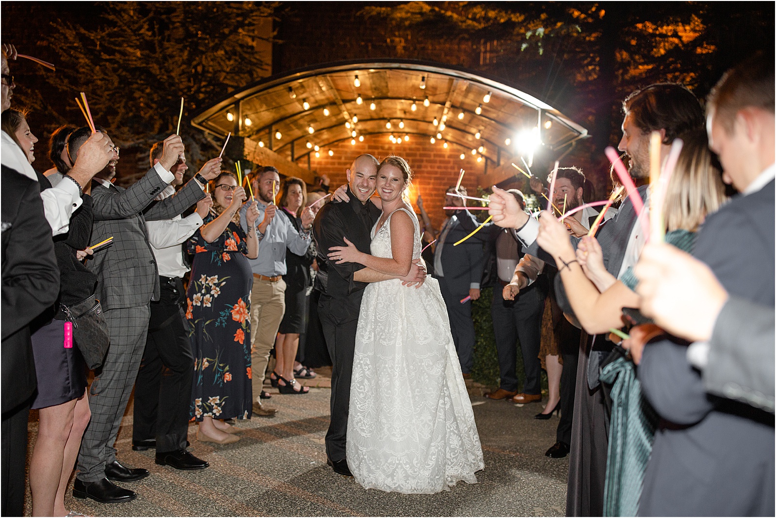 Married couple leaving their downtown Greenville Wedding through glowsticks