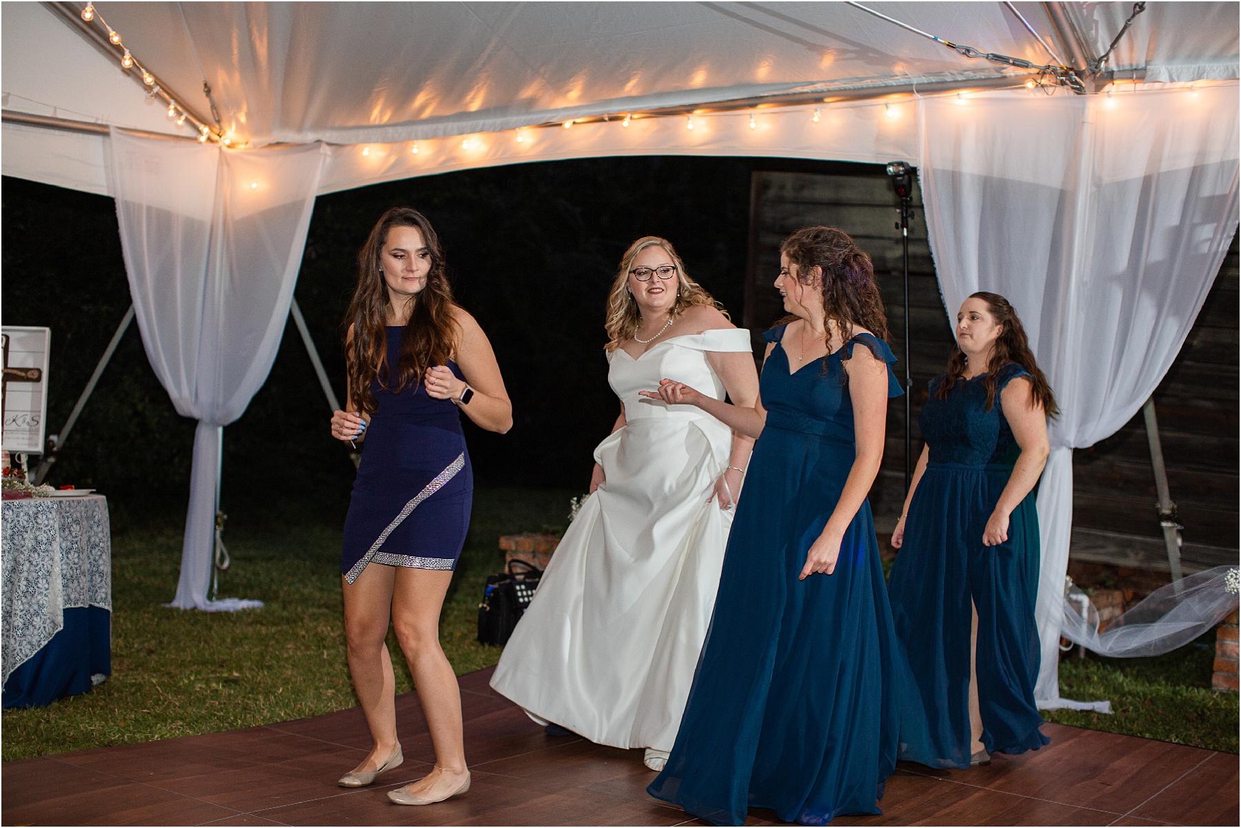 bride in wedding dress dances with friends at reception