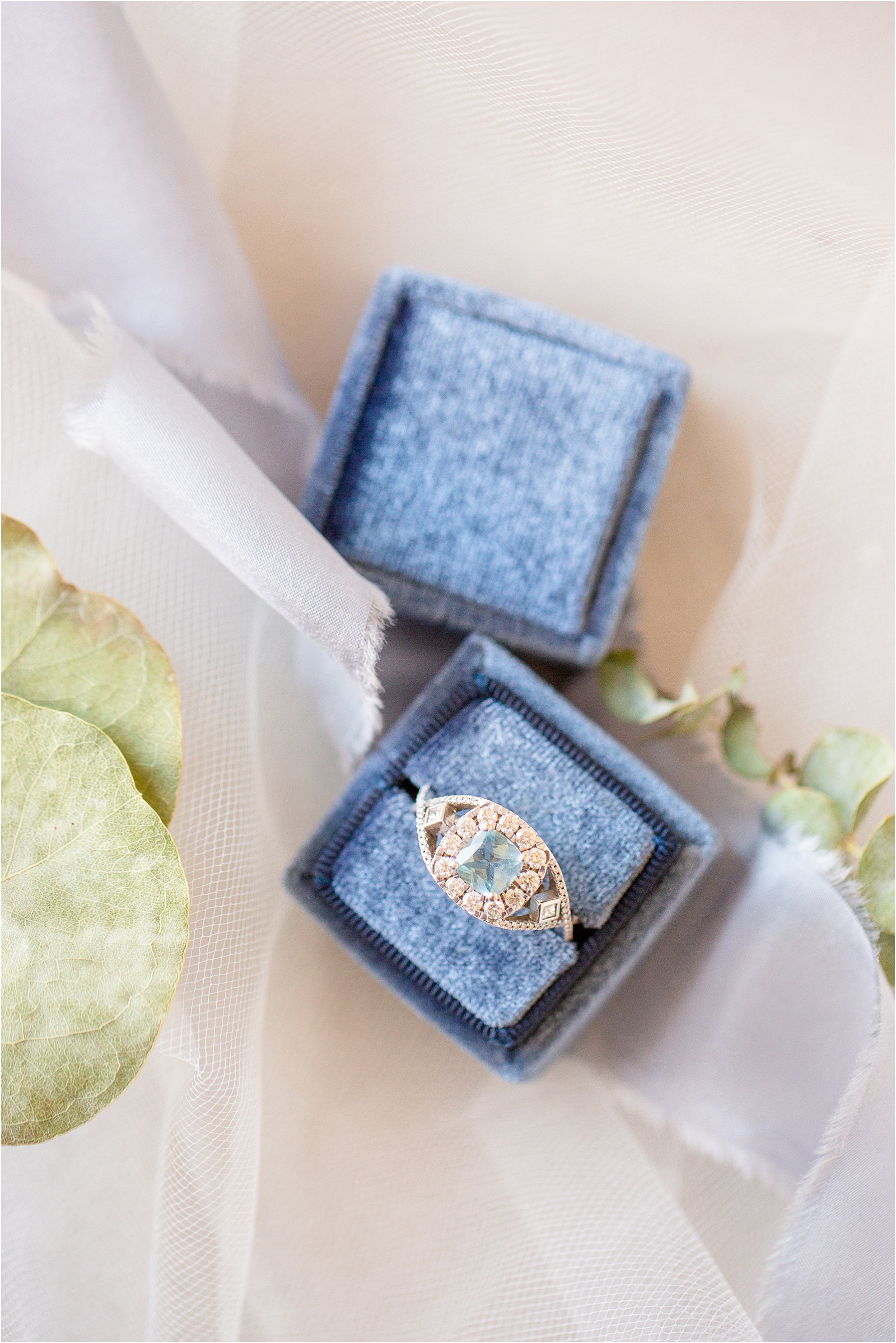 woman's engagement ring in blue ring box