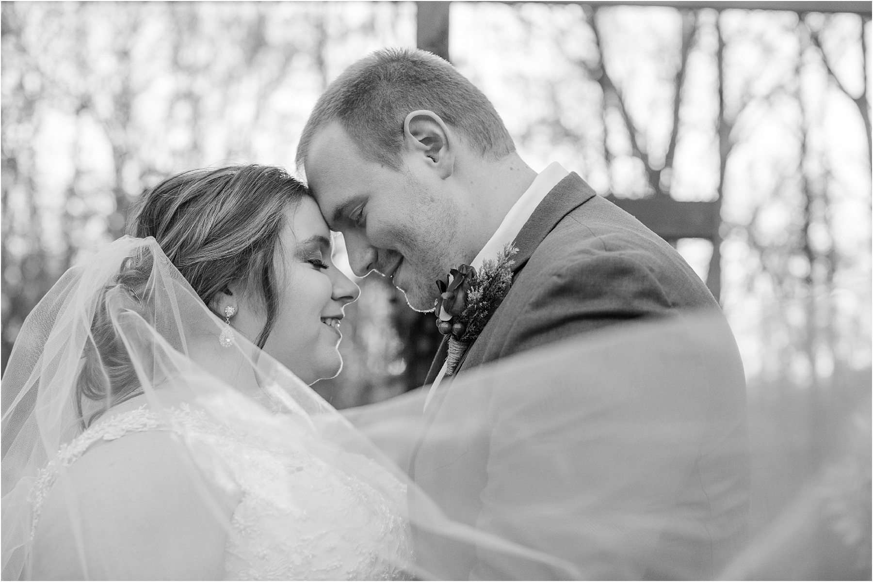 black and white of newlywed couple in front of cross