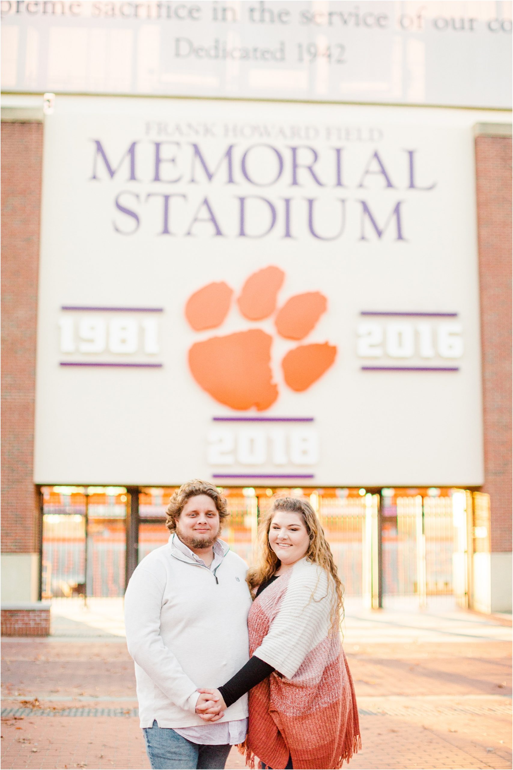 Engaged man and woman standing in front of Death Valley football stadium