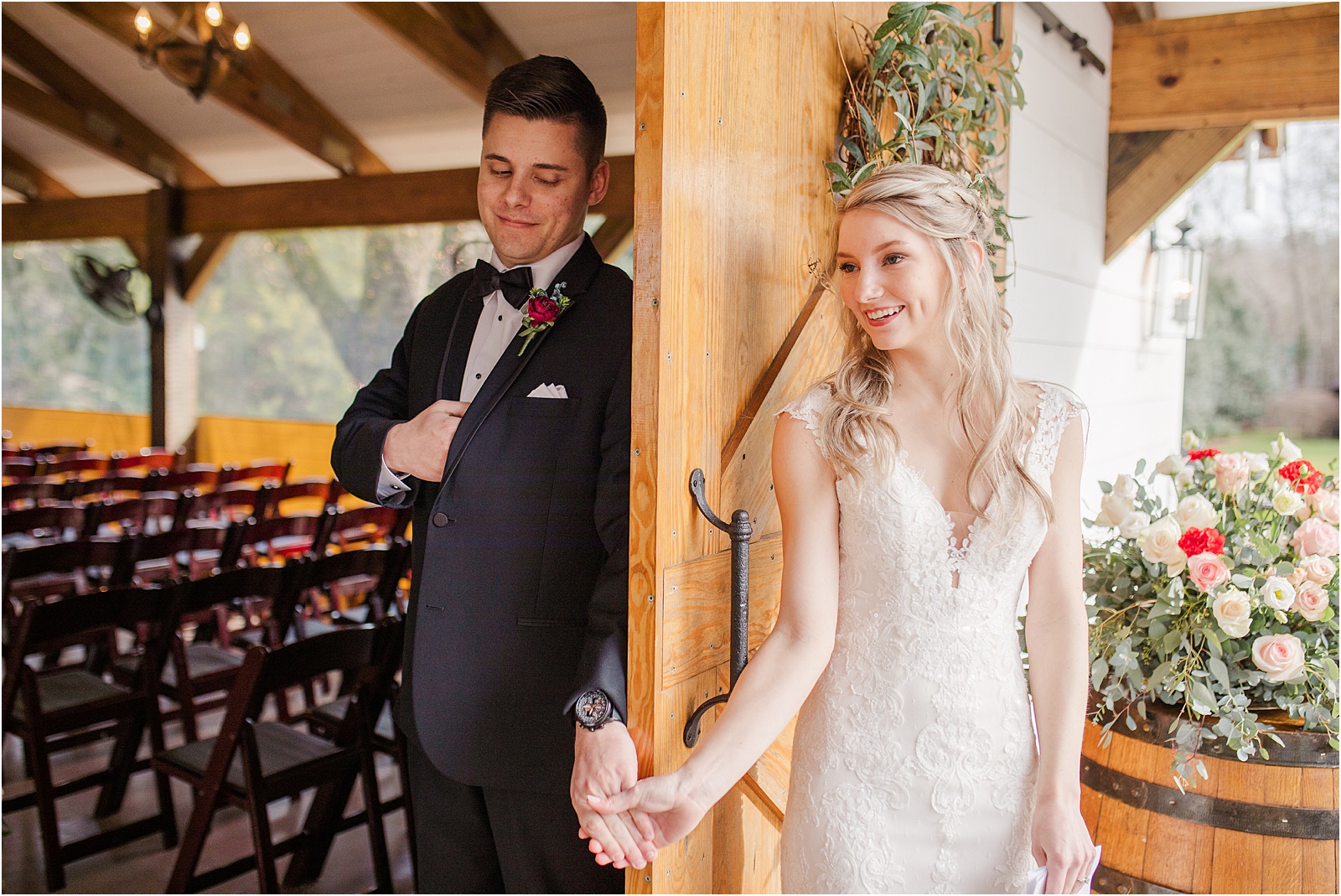 Groom and bride holding hands across door before ceremony