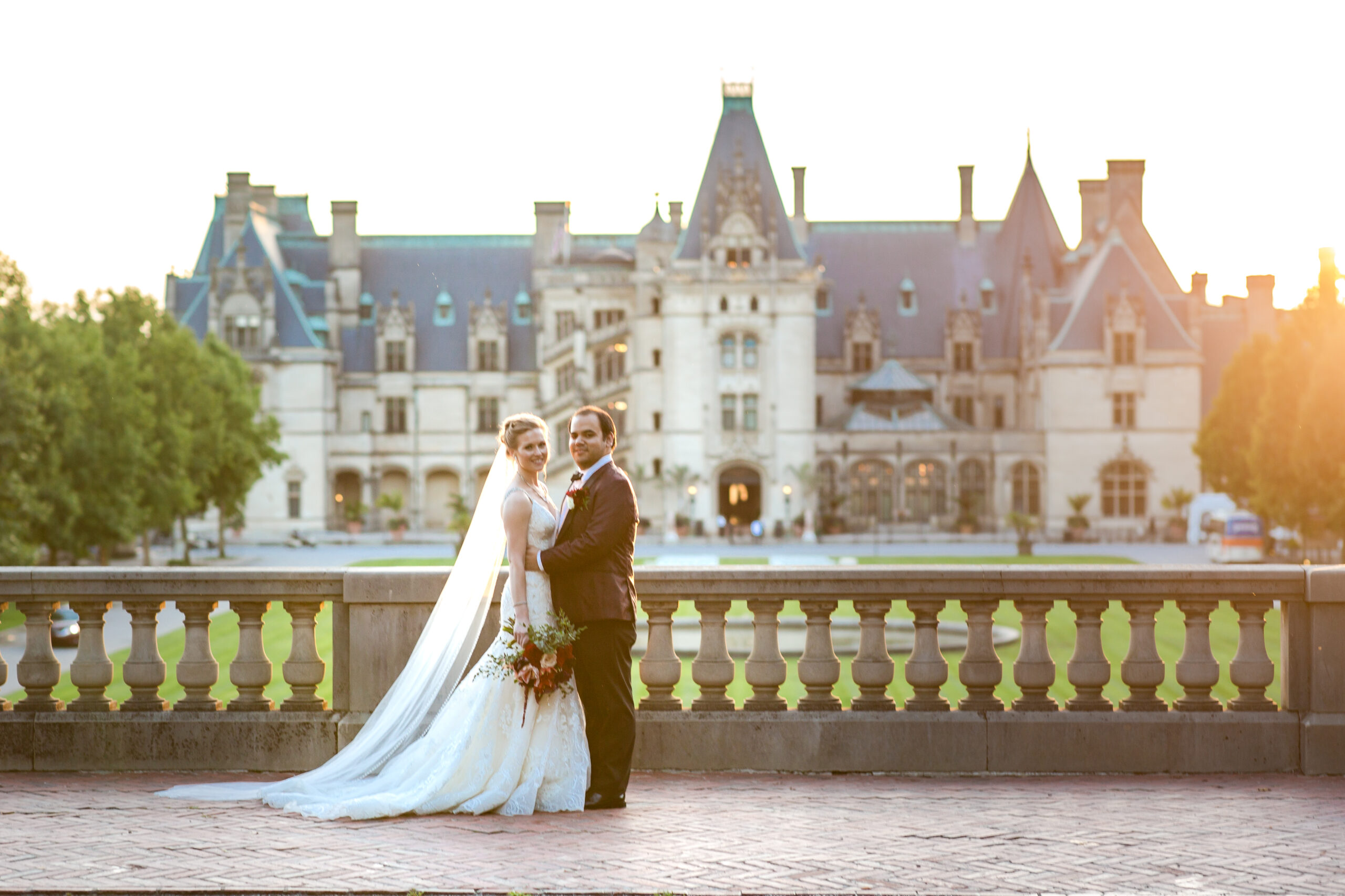 Just married couple posing in front of the Biltmore Estate house after their wedding 