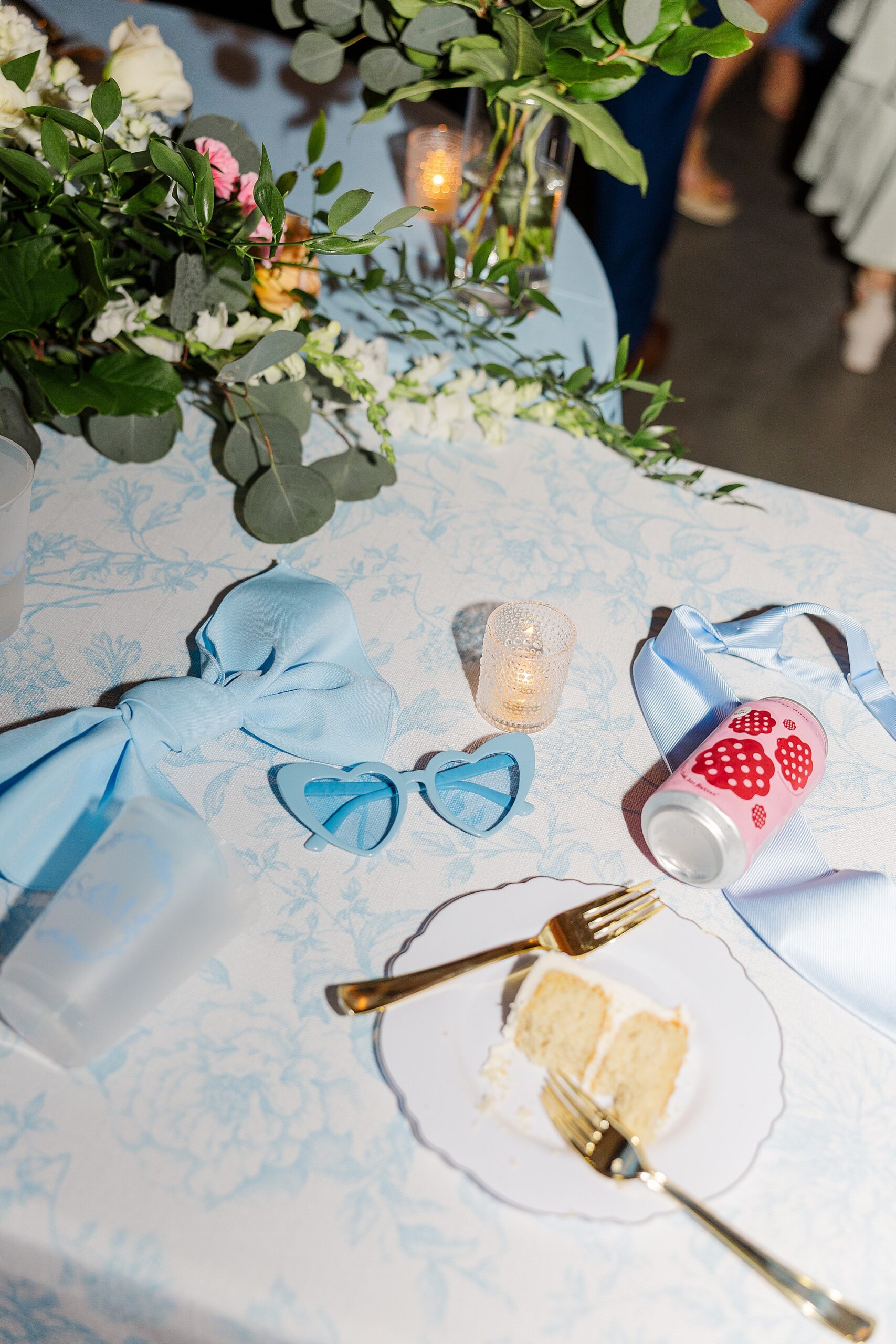 Reception table detail with blue linens, florals, and candlelight